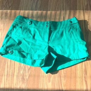 Green cache short with silver tone buttons.
